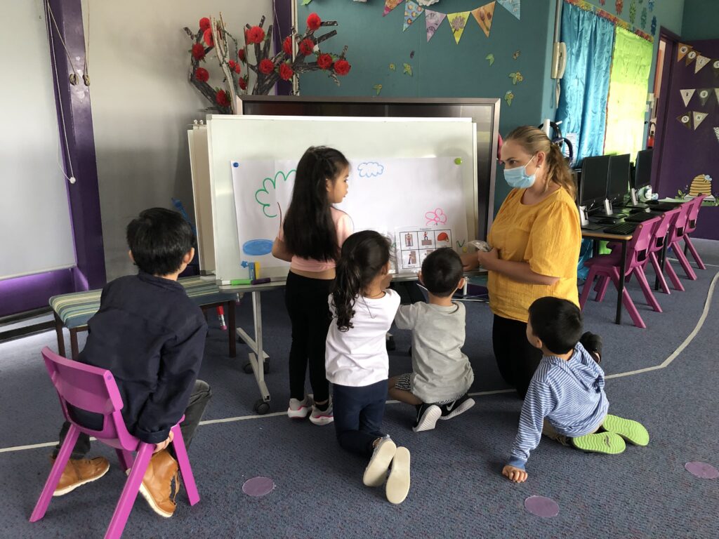 Participants sitting and observing during an activity with one of our early intervention speech pathologists, Rosie.