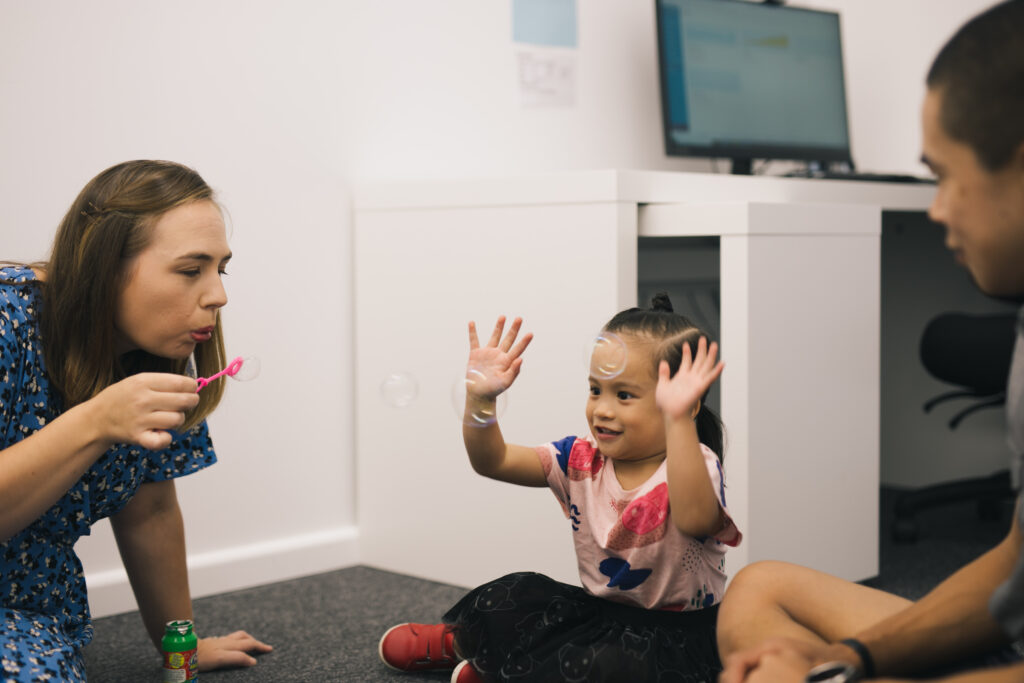 Rosie blowing bubbles with a young client.